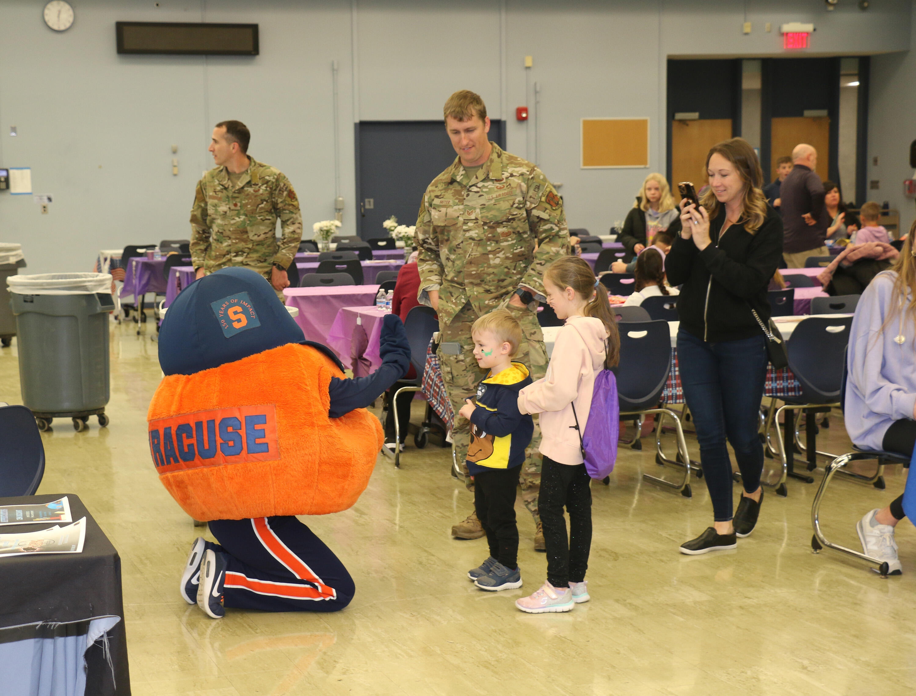 Military families greeting Otto the Orange at Purple Up Night